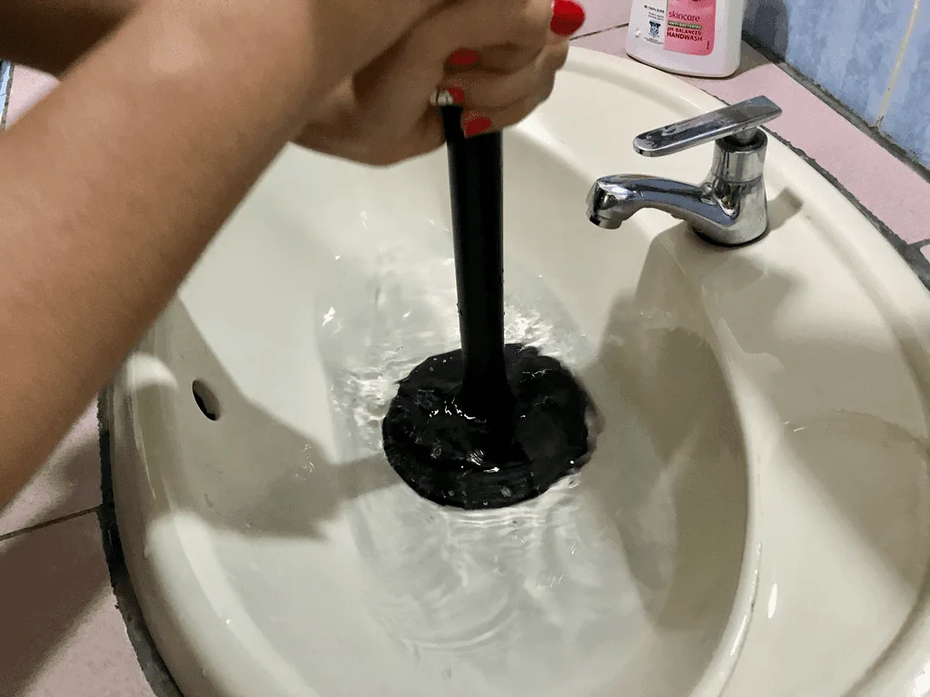 Femme qui débouche un évier