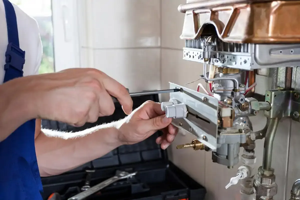 Plombier qui répare un chauffage électrique