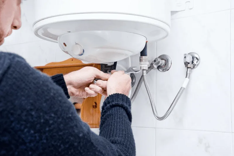 Plombier qui vidange un chauffe eau